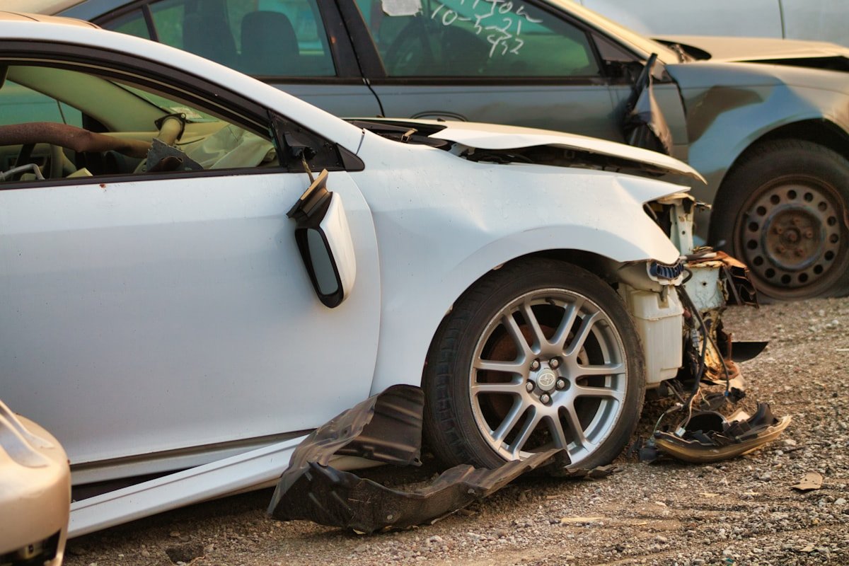 Baltas automobilis po eismo įvykio, apgadinta priekinė dalis