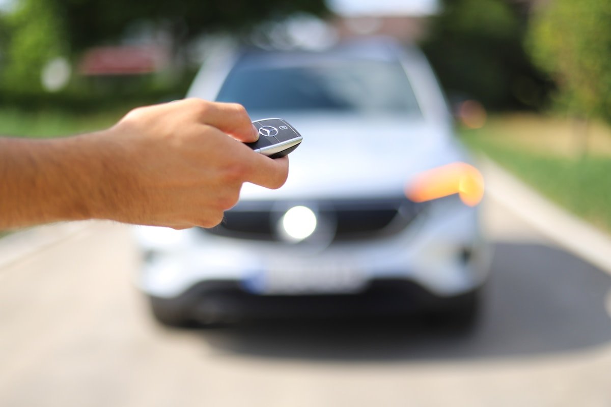 Automobilio raktelis rankoje priešais stovintį automobilį