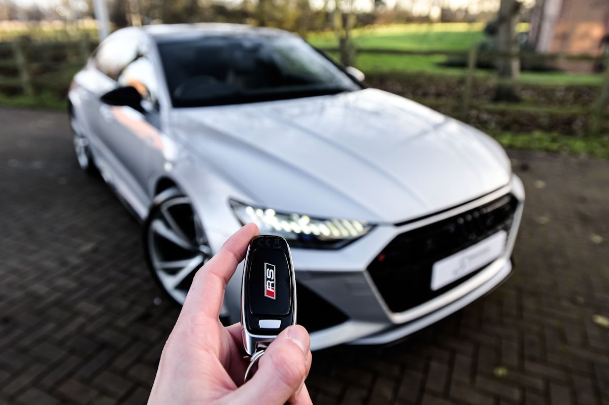 Audi automobilis ir jo raktelis rankoje