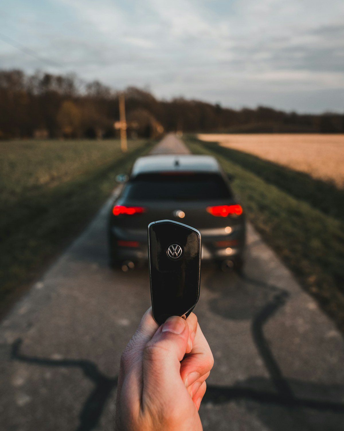 Automobilio raktelis ir automobilis kaimo kelyje