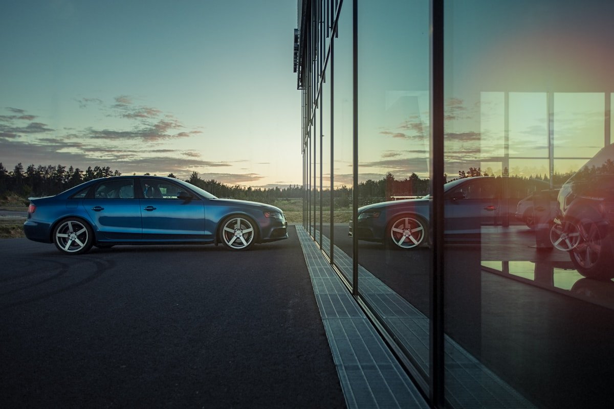 Mėlynas automobilis prie pastato
